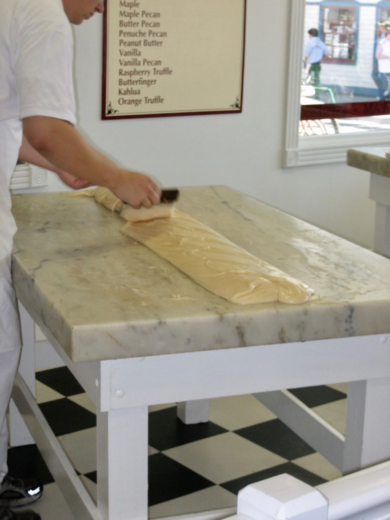 A worker turns the fudge as it cools.