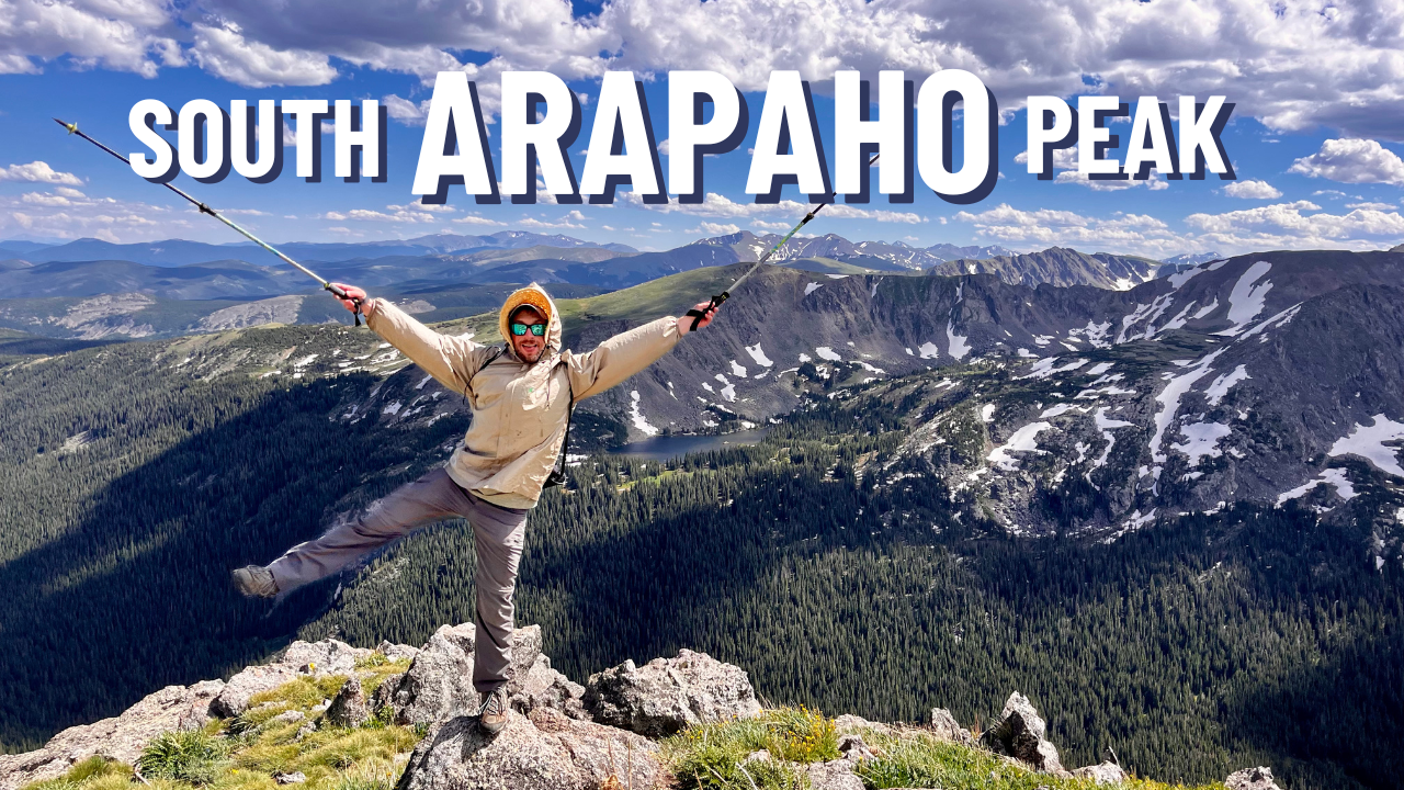 man with mountains behind and words south arapaho peak